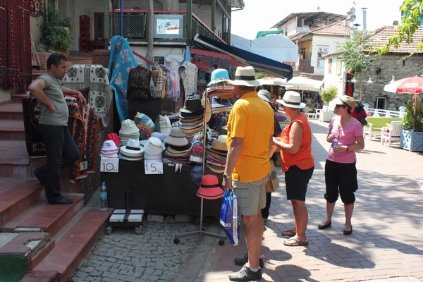 Turistas ingleses comprando sombreros a un comerciante local —  Fotos de Stock