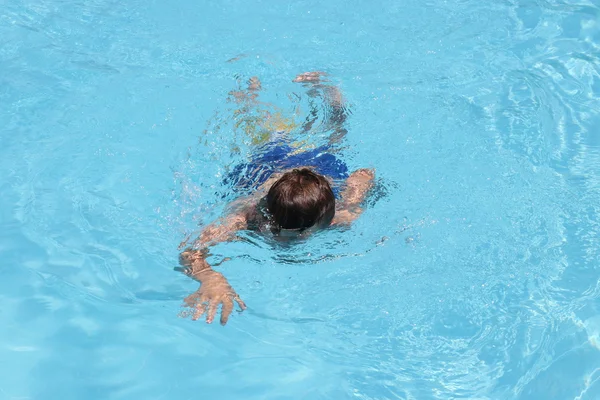 Ein kleiner Junge schwimmt — Stockfoto