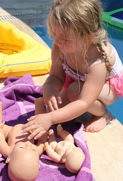 A young girl playing with her doll — Stock Photo, Image