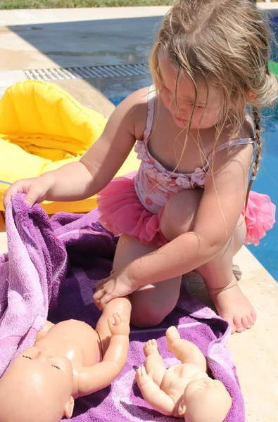 A young girl playing with her doll — Stock Photo, Image