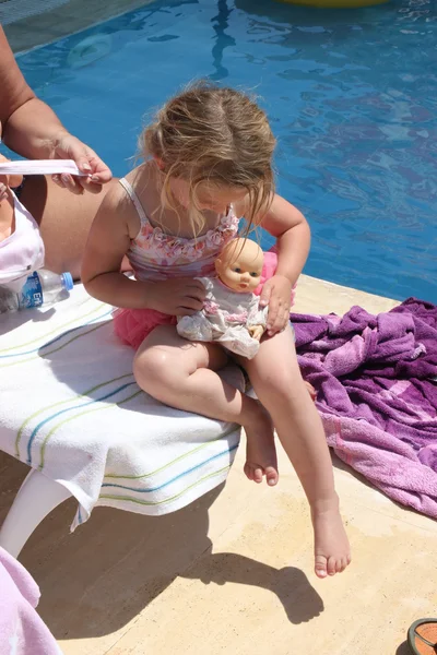 A young girl playing with her doll — Stock Photo, Image