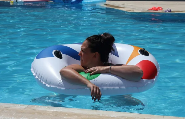 Eine junge Frau, die sich in einem Schwimmbad abkühlt — Stockfoto