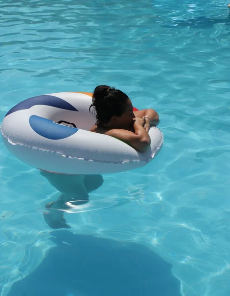 En ung dam svalkar dig i en pool — Stockfoto