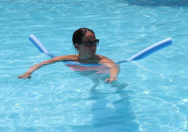 Uma jovem senhora se refrescando em uma piscina — Fotografia de Stock