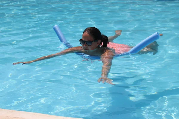 Una joven que se refresca en una piscina — Foto de Stock