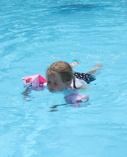 Une jeune fille portant des brassards comme aides à la flottaison — Photo