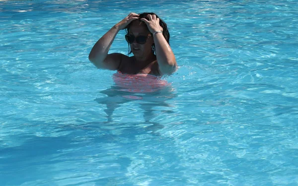 Una joven que se refresca en una piscina — Foto de Stock