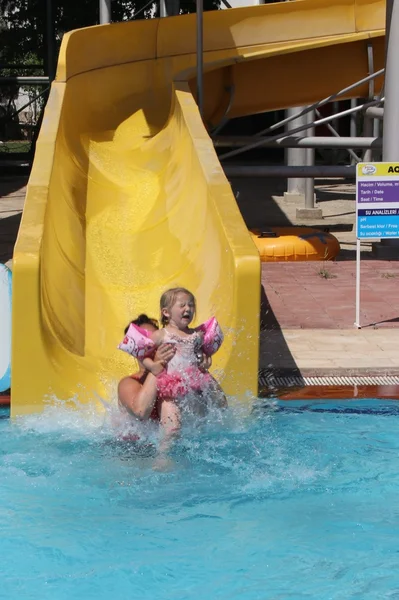 Mutter und Tochter amüsieren sich auf der Wasserrutsche — Stockfoto