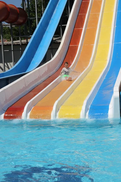 Ein kleiner Junge hat Spaß auf einer Wasserrutsche — Stockfoto