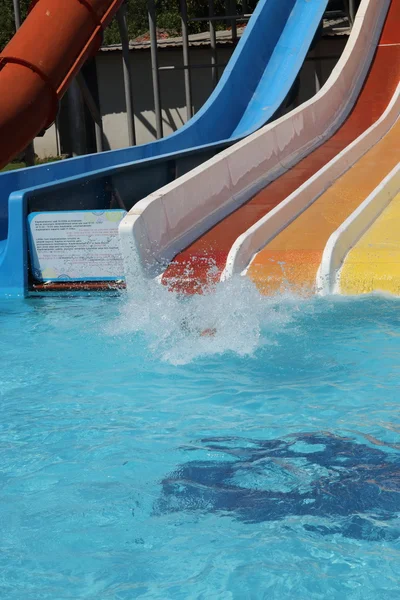 Un jeune garçon qui s'amuse sur un toboggan aquatique — Photo