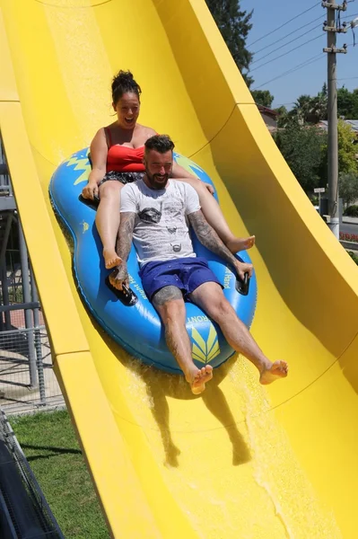 Ein englisches Paar amüsiert sich auf einer Wasserrutsche — Stockfoto