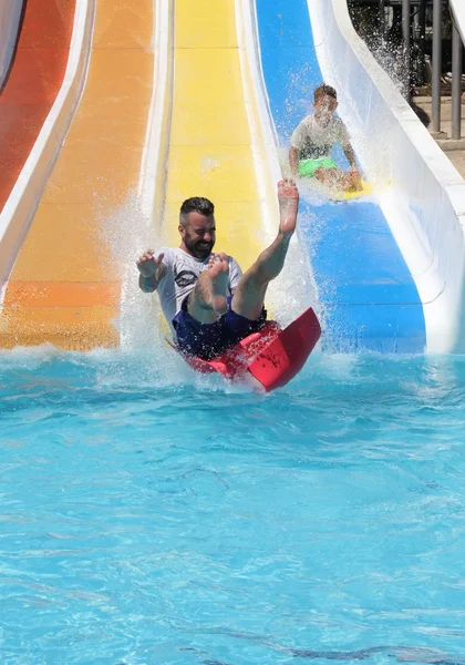 Un père et son fils s'amusent sur un toboggan aquatique — Photo