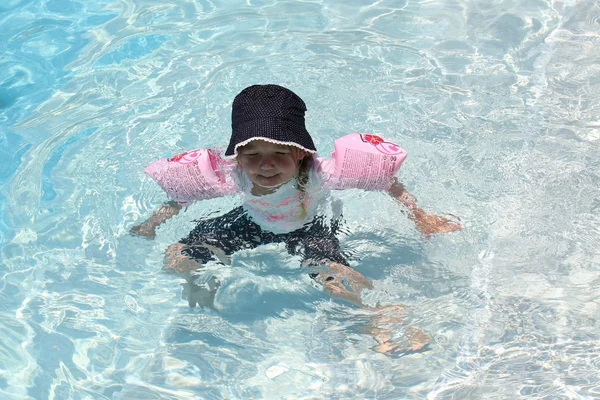 Uma jovem usando braçadeiras como auxiliares de flutuação — Fotografia de Stock