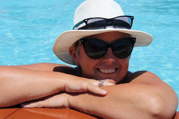 Uma senhora inglesa relaxando em uma piscina — Fotografia de Stock