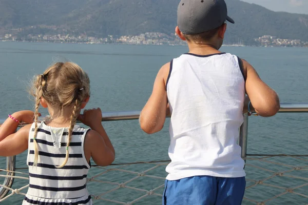 A brother and sister looking out to sea — Stock Photo, Image