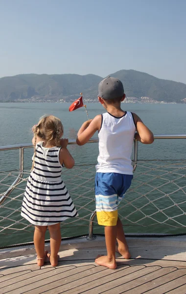 A brother and sister looking out to sea — Stock Photo, Image