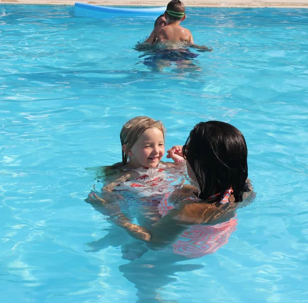 Una familia joven divirtiéndose en una piscina —  Fotos de Stock