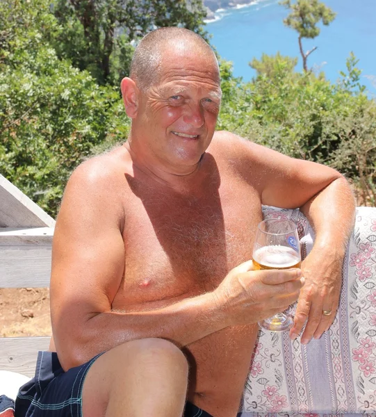 An englishman relaxing in the sunshine with a drink — Stock Photo, Image