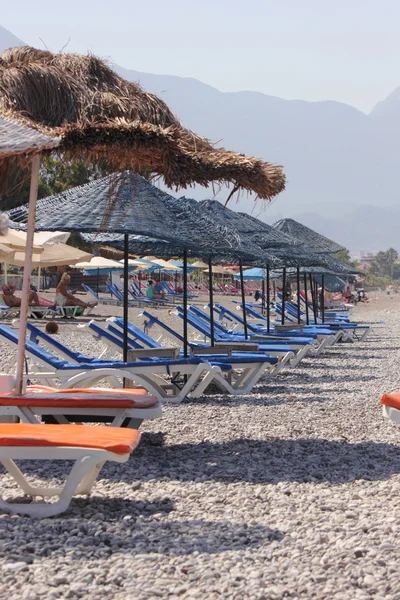 Liegestühle und Sonnenschirme am Strand — Stockfoto