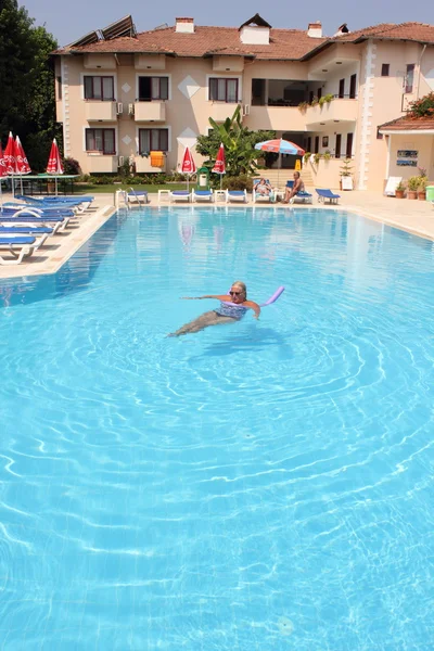 Eine englische Dame entspannt sich im Swimmingpool — Stockfoto