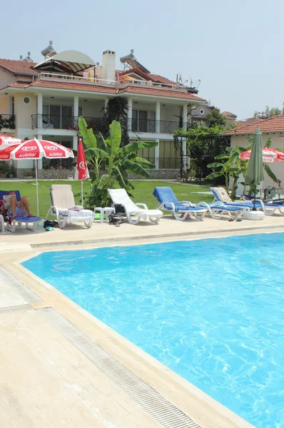 Una piscina muy azul con tumbonas y apartamentos —  Fotos de Stock