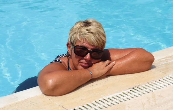Uma senhora relaxando na piscina — Fotografia de Stock