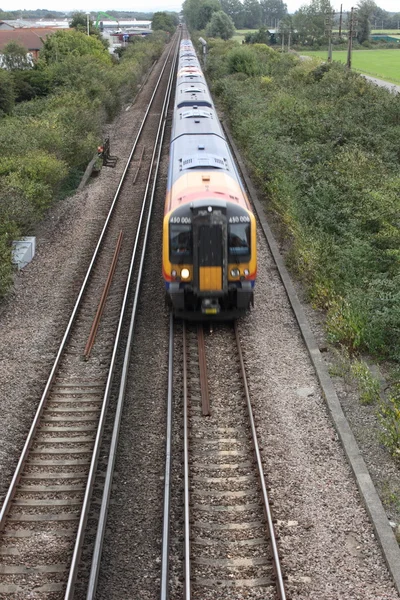 Ett tåg som färdas längs järnvägsspår — Stockfoto