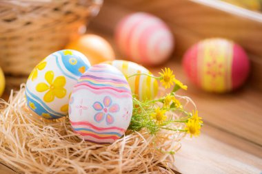 Mutlu Paskalya günleri. Yuvadaki renkli yumurtalar ve pencere ışıklandırmalı ağaçtaki çiçekler..