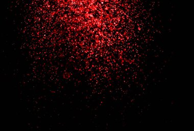 Kutlama, düğün ve sevgililer günü için siyah zemin üzerine parlak kırmızı parıltı düşen parçacıklar..