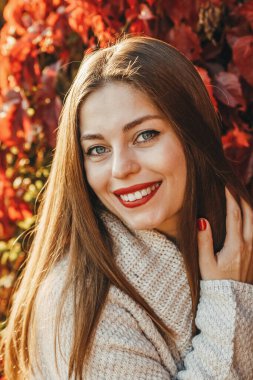 Kırmızı arka planda bir kadının yakın plan portresi ve bağırışı.