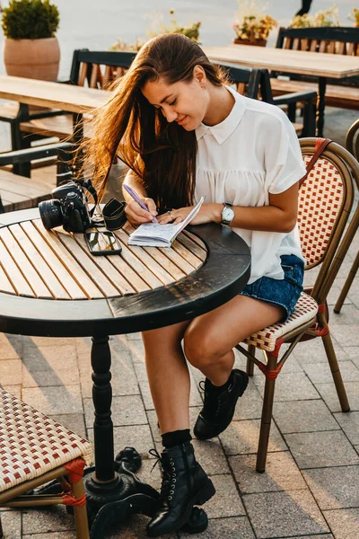 Güzel bir kadın terasta kahve masasında oturuyor. O iyi.