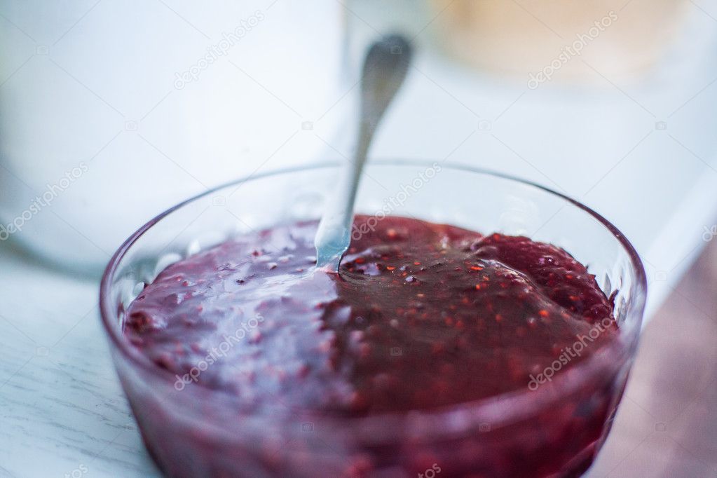 Strawberry jam in bowl with teaspoon