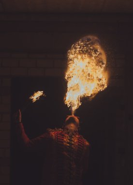 Ateş sanatçısı karanlıkta ateş püskürtür.