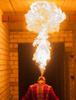 Ateş sanatçısı karanlıkta ateş püskürtür.