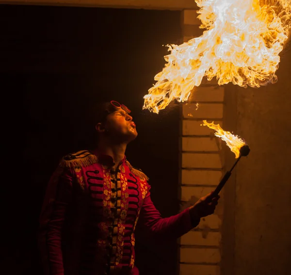 Artiste du spectacle de feu respirer le feu dans l'obscurité — Photo