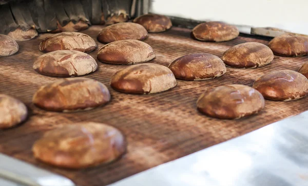 焼いたパンは、パン屋で生産ライン — ストック写真