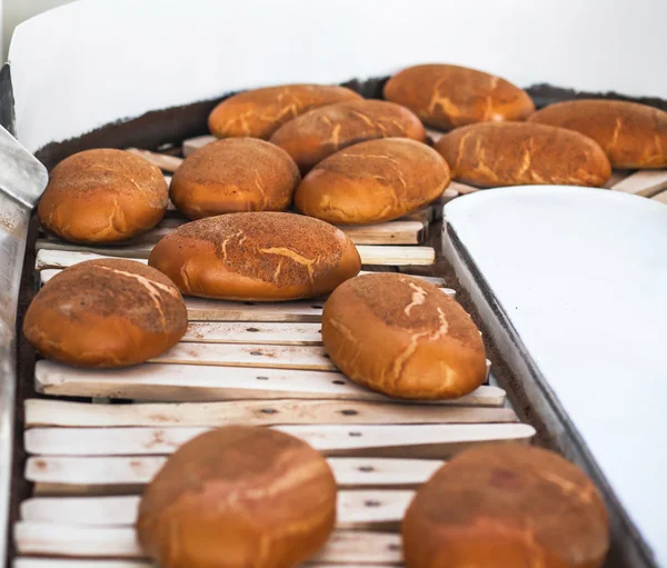 Nybakat bröd på produktionslinjen på bageriet — Stockfoto