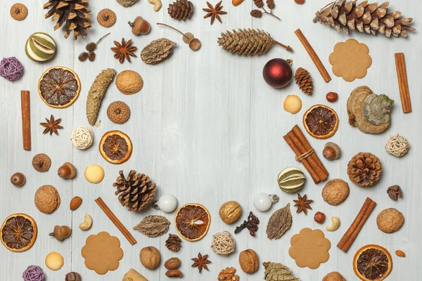 Fondo de Navidad de conos, canela, nueces, especias, galletas en tablas ligeras. En el centro hay espacio libre para el texto en forma de círculo — Foto de Stock