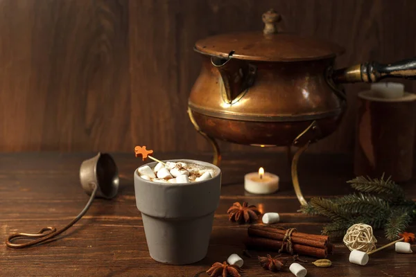 Vidrio gris con cacao y malvaviscos en una mesa de madera con decoración navideña, especias y una tetera de cobre vintage. horizontalmente con el espacio — Foto de Stock