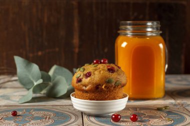 Yaban mersinli ev yapımı balkabağı keki ve koyu ahşap arka planda bir bardak deniz dikenli çay. Alçak tuş, yakın plan.