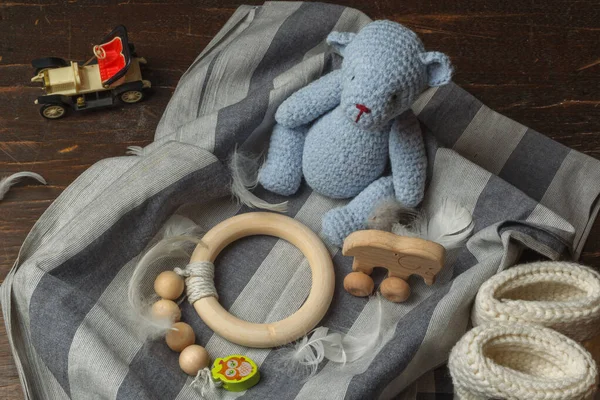 Boîte hygge pour nouveau-né, ours en tricot bleu, courroie de dentition en bois naturel, chaussons en tricot blanc. Un cadeau pour un enfant dans une boîte. — Photo