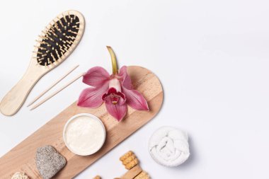 Doğal malzemelerden yapılmış vücut ve cilt bakımı için çevre dostu eşyalar. Tahta tarak, manikür çubukları, sünger taşı, kuru masaj fırçası. Beyaz bir arkaplan üzerinde boşluk ile yerleşim