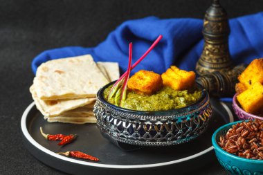 Palak paneer, geleneksel Hint mutfağı. Ispanak, sebze, baharat ve baharatla kızartılmış ev yapımı yumuşak peynir. Mayasız tortilla ve pilav ile servis edilir. Vejetaryen, yağsız