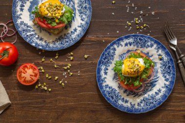 Hardal soslu haşlanmış yumurtalı sandviç, taze sebze ve fasulye filizi. Eski boyalı tabaklarda. Yatay, üst görünüm