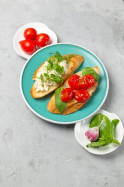 Geleneksel İtalyan aperatifi, aperatif, antipasto. Kurutulmuş domates, fesleğen, ricotta ve mikro-yeşillik. Üst görünüm, yakın çekim