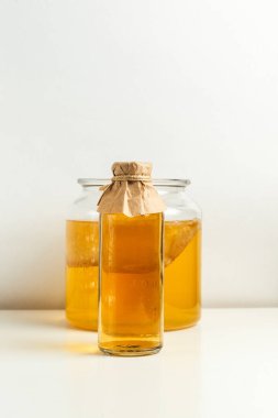 Tatlı ve ekşi karbonatlı mayalanmış Kombucha içeceği, evde kolayca yapılabilen sodanın yerine kullanılabilecek sağlıklı bir limonata. Aydınlık bir arkaplanda. Dikey olarak, boşluğu kopyala