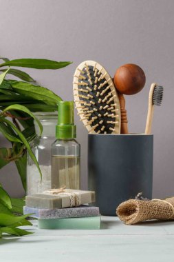 Kişisel bakım kavramı, banyo ve duş için çevre dostu bir set. Doğal şampuan, banyo tuzu, ahşap tarak, bambu diş fırçası. Yakın çekim, dikey, seçici odaklanma