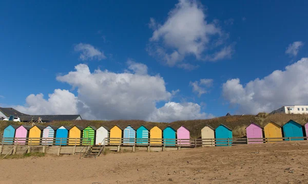Tradiční barevné anglické přímořské scény s plážové chatky na pláži a modrá obloha s pastelovými barvami — Stock fotografie