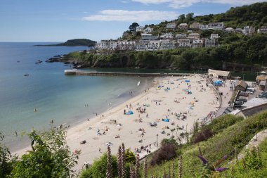 Güzel hava, ziyaretçileri 11 Temmuz 2020 'de Looe Cornwall' daki yaz güneşi için sahile geri çekti.