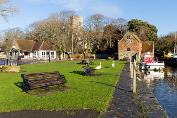 Christchurch Dorset Anglia Egyesült Királyság hattyúkkal folyónál, háttérben a templom — Stock Fotó